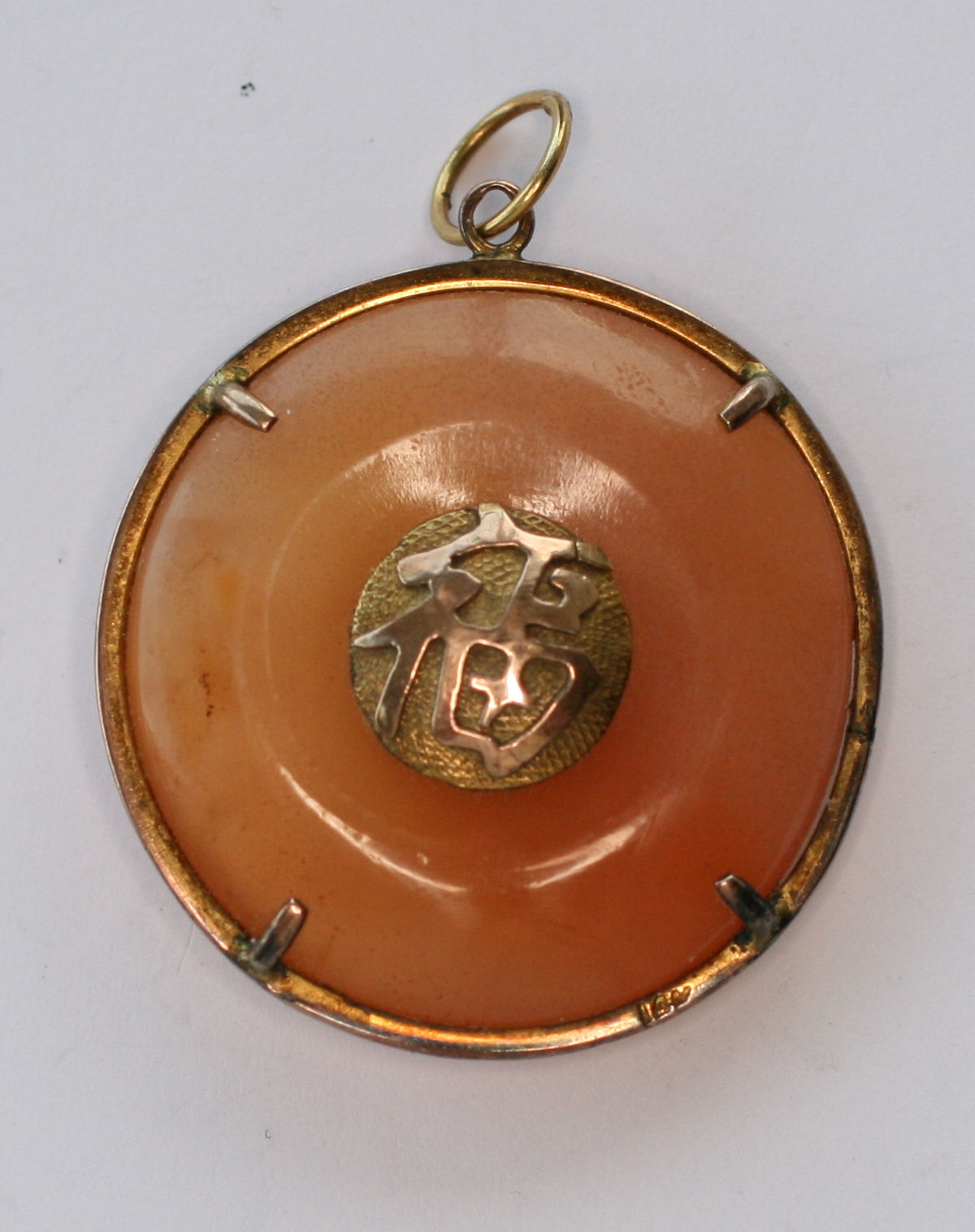 A gilt metal mounted jadeite pendant