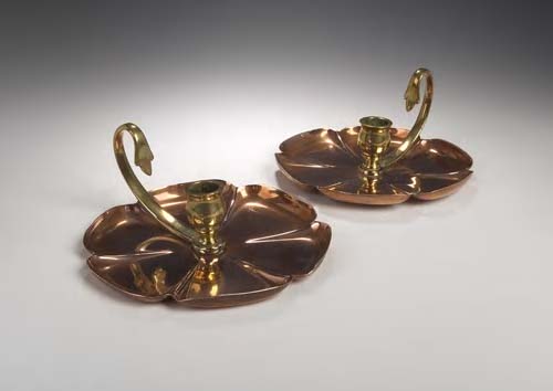 A pair of W.A.S. Benson & Co. copper and brass chamber sticks,