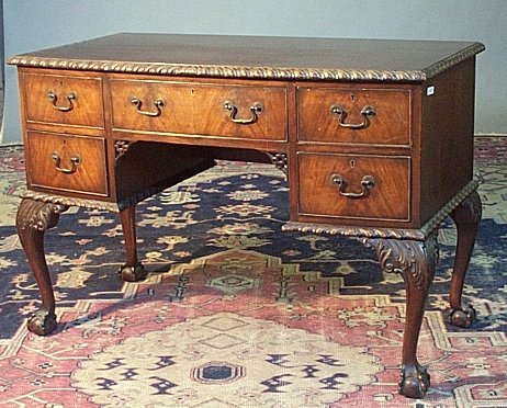 A mahogany kneehole bowfront desk