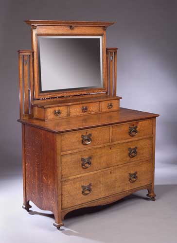 An Art Nouveau oak bedroom suite comprising a wardrobe