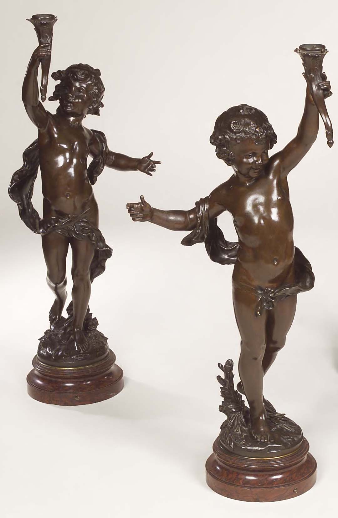 A pair of bronze torcheres, after Auguste Moreau,