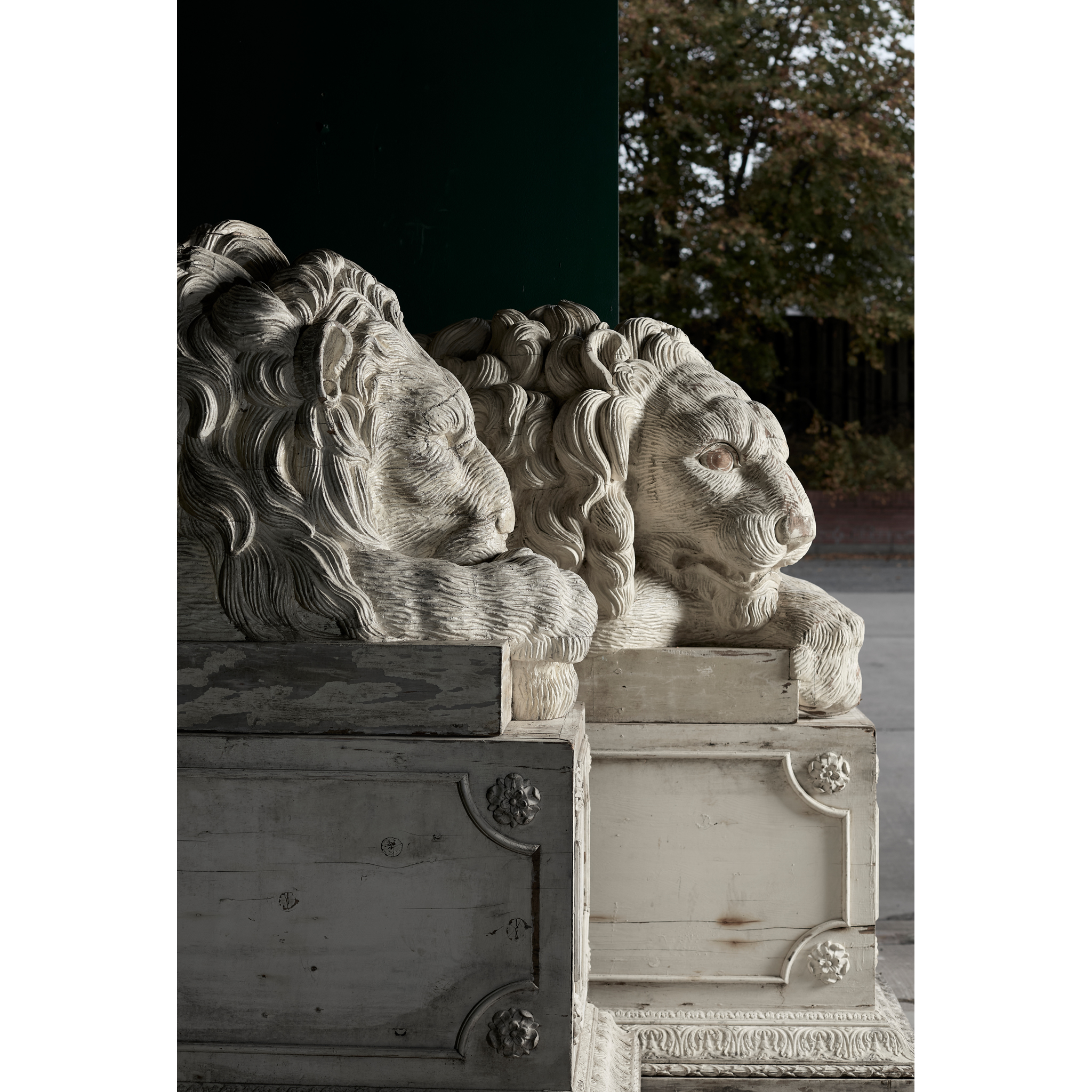 PAIR OF MONUMENTAL CARVED AND PAINTED RECUMBENT LIONS AND PLINTHS, AFTER THE MODELS BY ANTONIO CANOVA