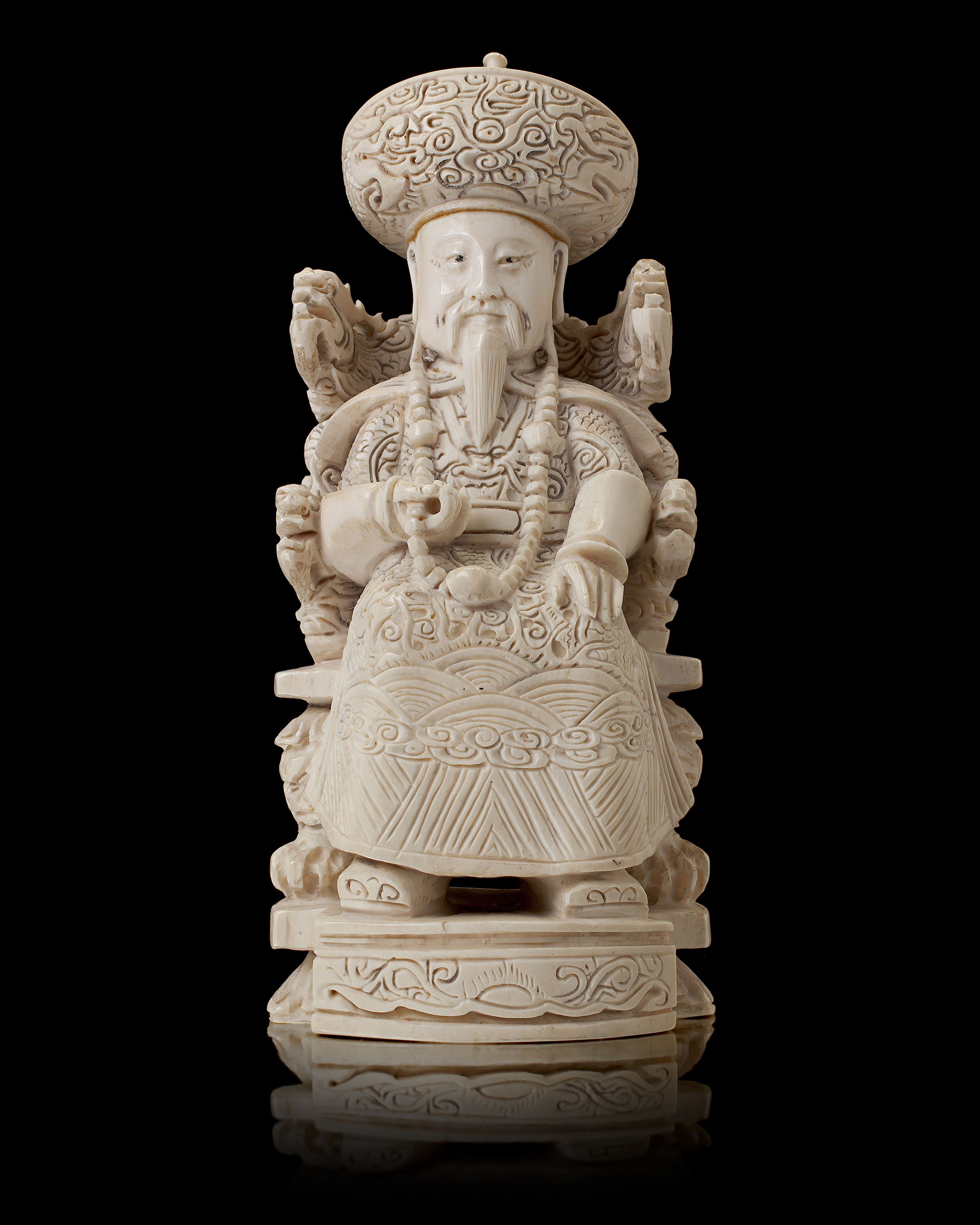 PAIR OF CHINESE CARVED IVORY FIGURES OF A SEATED OFFICIAL AND COMPANION