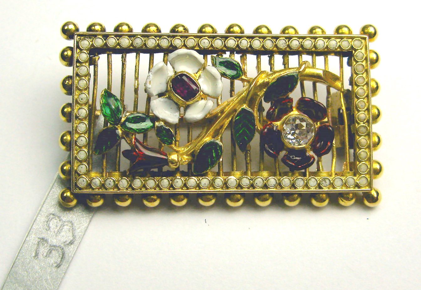 An early 20th century enamelled and multi-gem set brooch