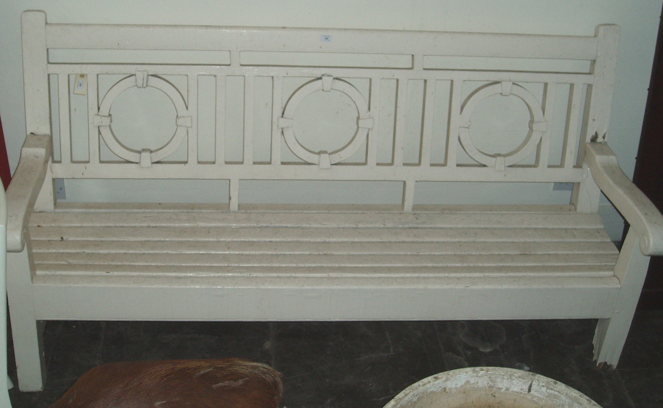 An Edwardian overpainted garden bench, designed in the manner of George Walton,