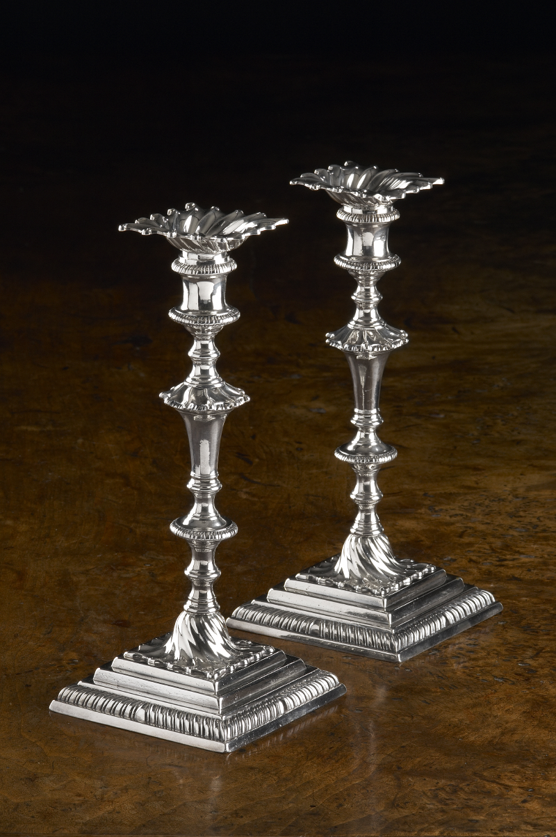 A pair of George III cast silver table candlesticks