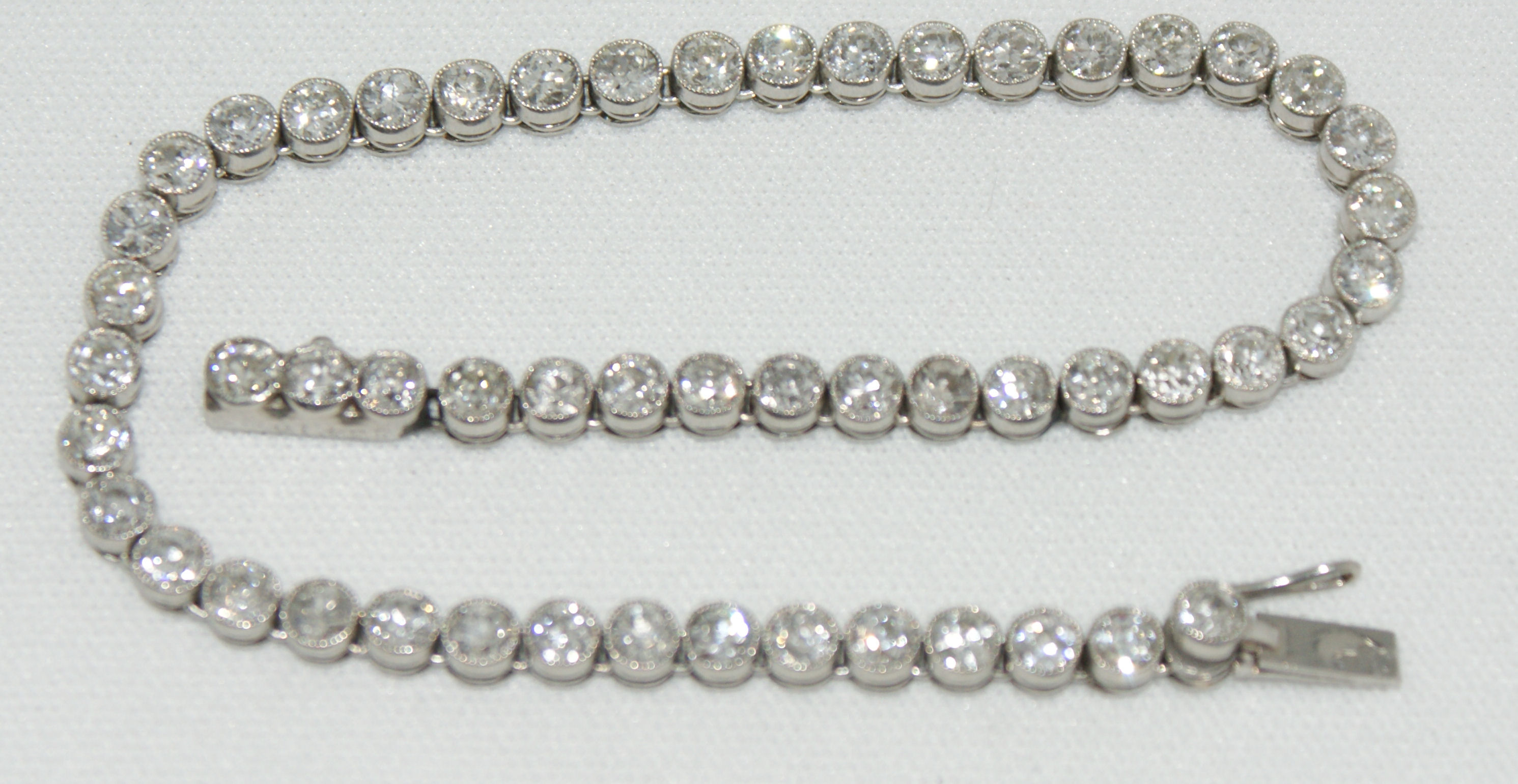 A French white gold and diamond line bracelet, on white metal