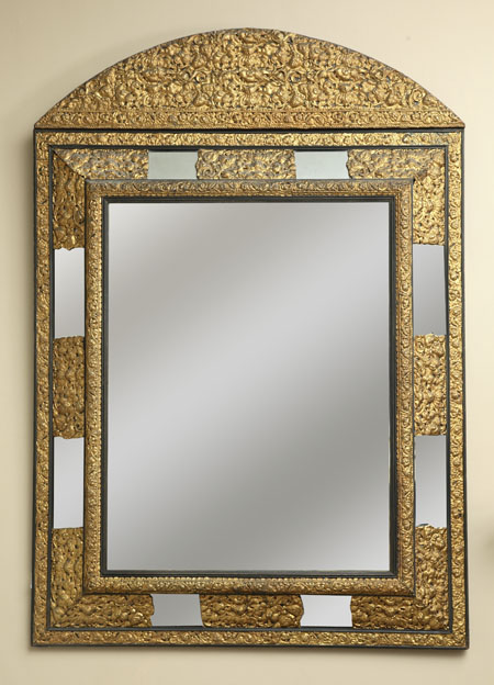 A French giltmetal and ebonised cushion wall mirror