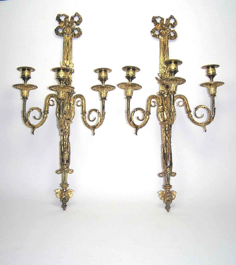 A pair of 19th century French gilt brass three-light wall appliques In the neoclassical taste