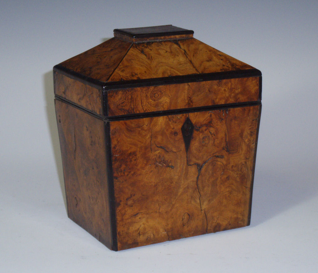 A Regency burr elm and ebony inlaid tea caddy