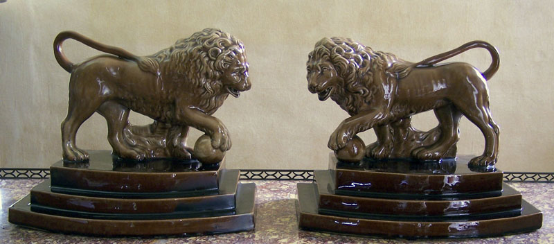 A pair of brown glazed pottery models of Medici lions