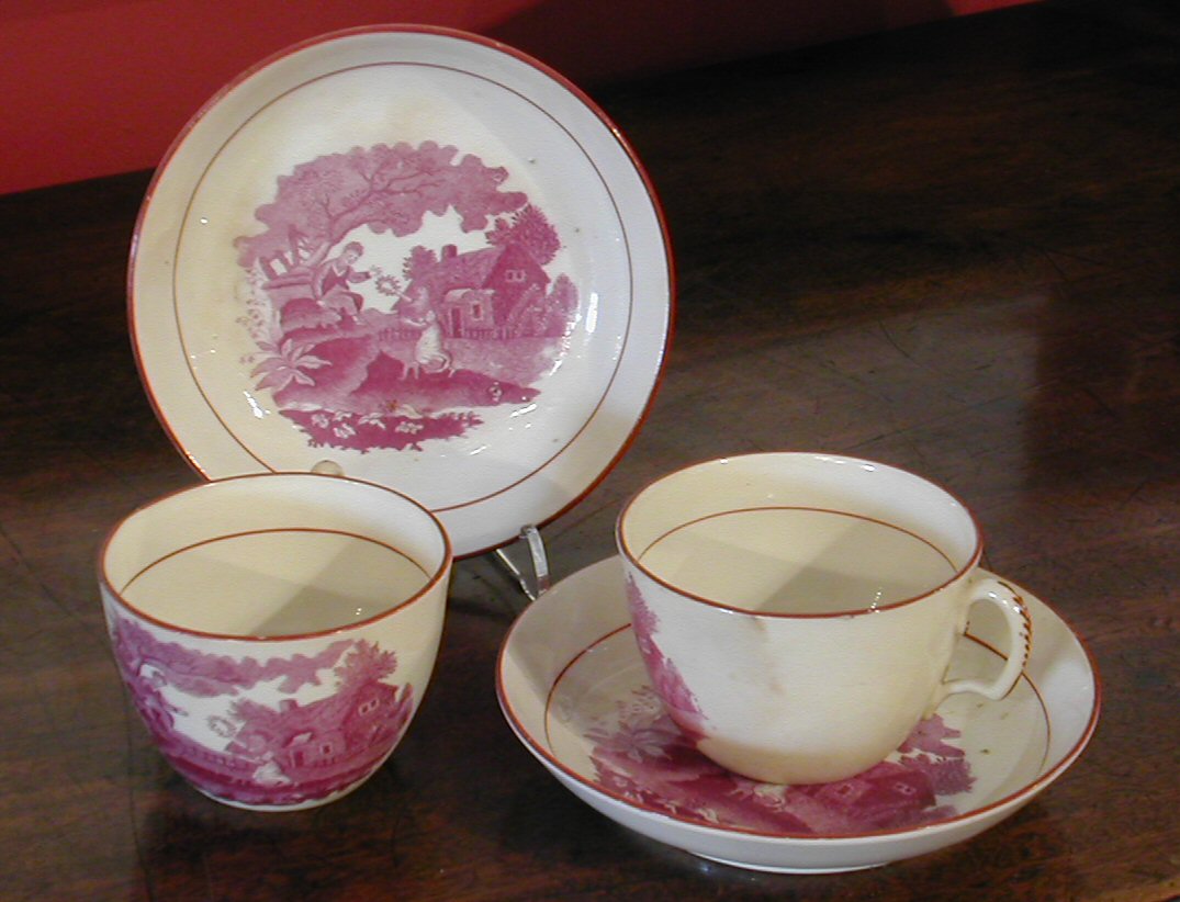 A set of four puce printed tea cups and three saucers,