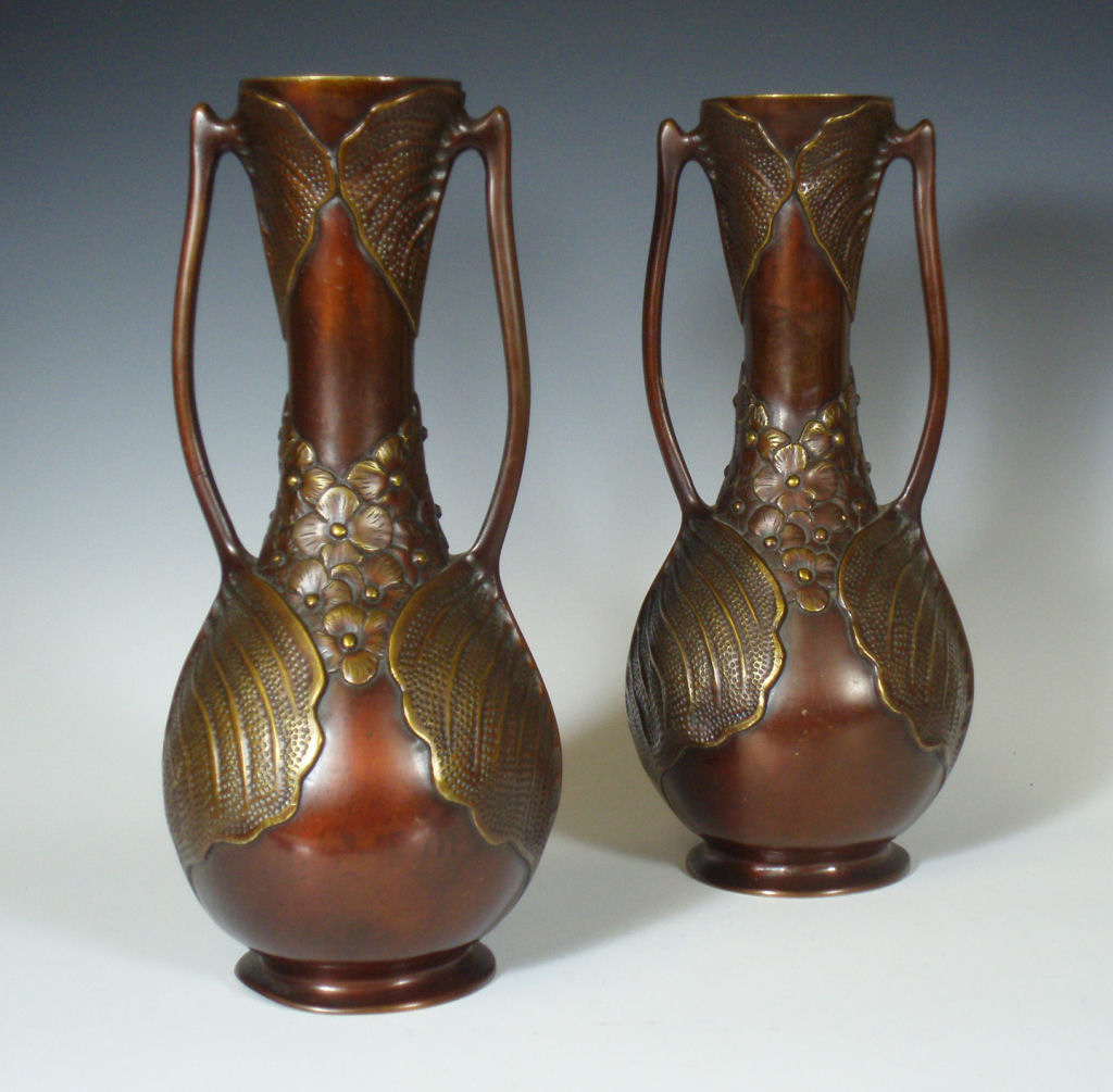 A pair of late 19th century foliate form lacquered bronze bottle vases