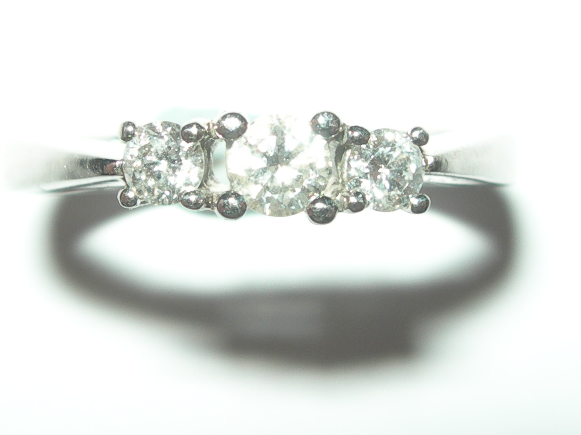 A modern platinum mounted three-stone diamond ring,