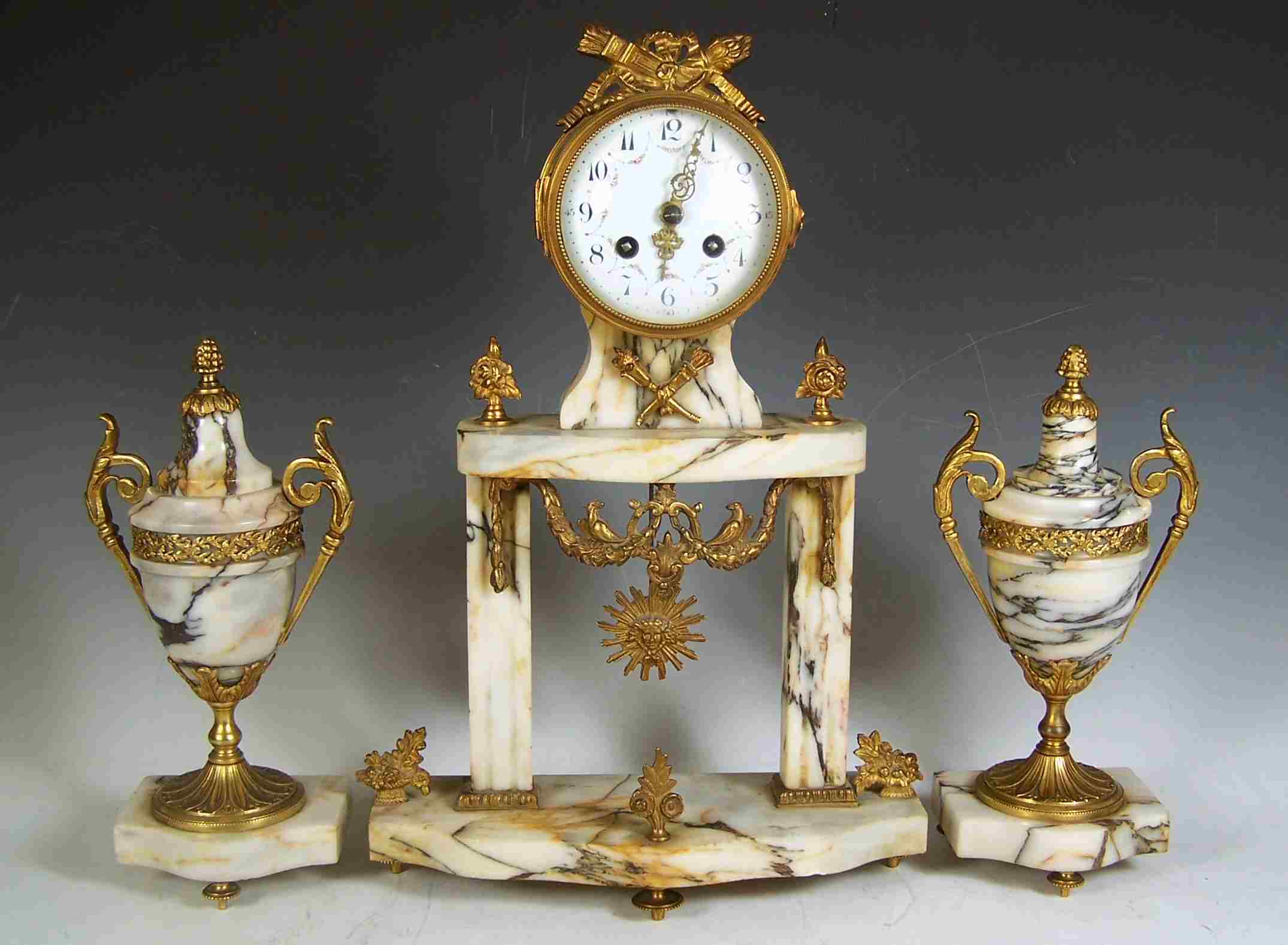 An Edwardian veined white marble and gilt metal clock garniture,