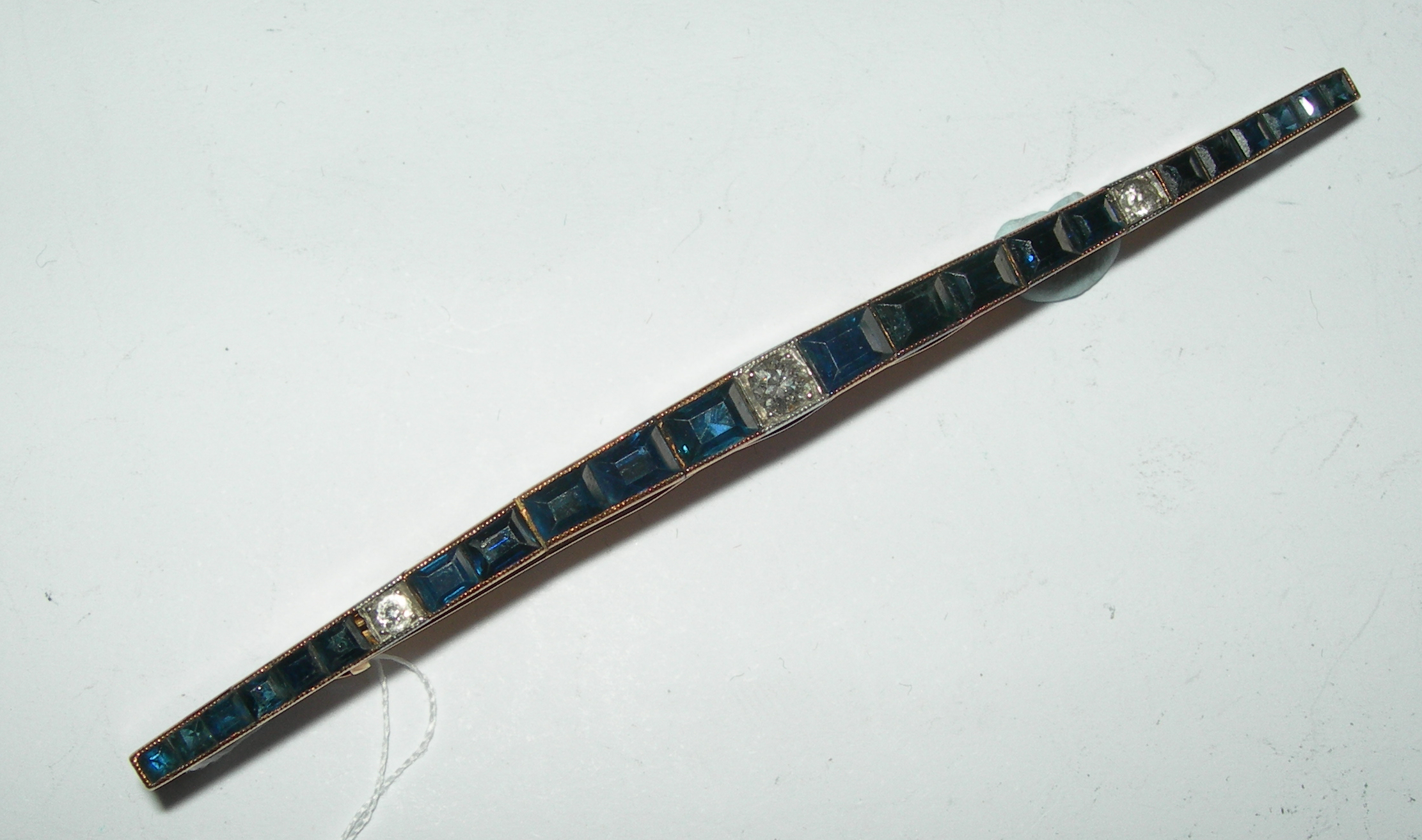 An unusual sapphire and diamond set bar brooch,