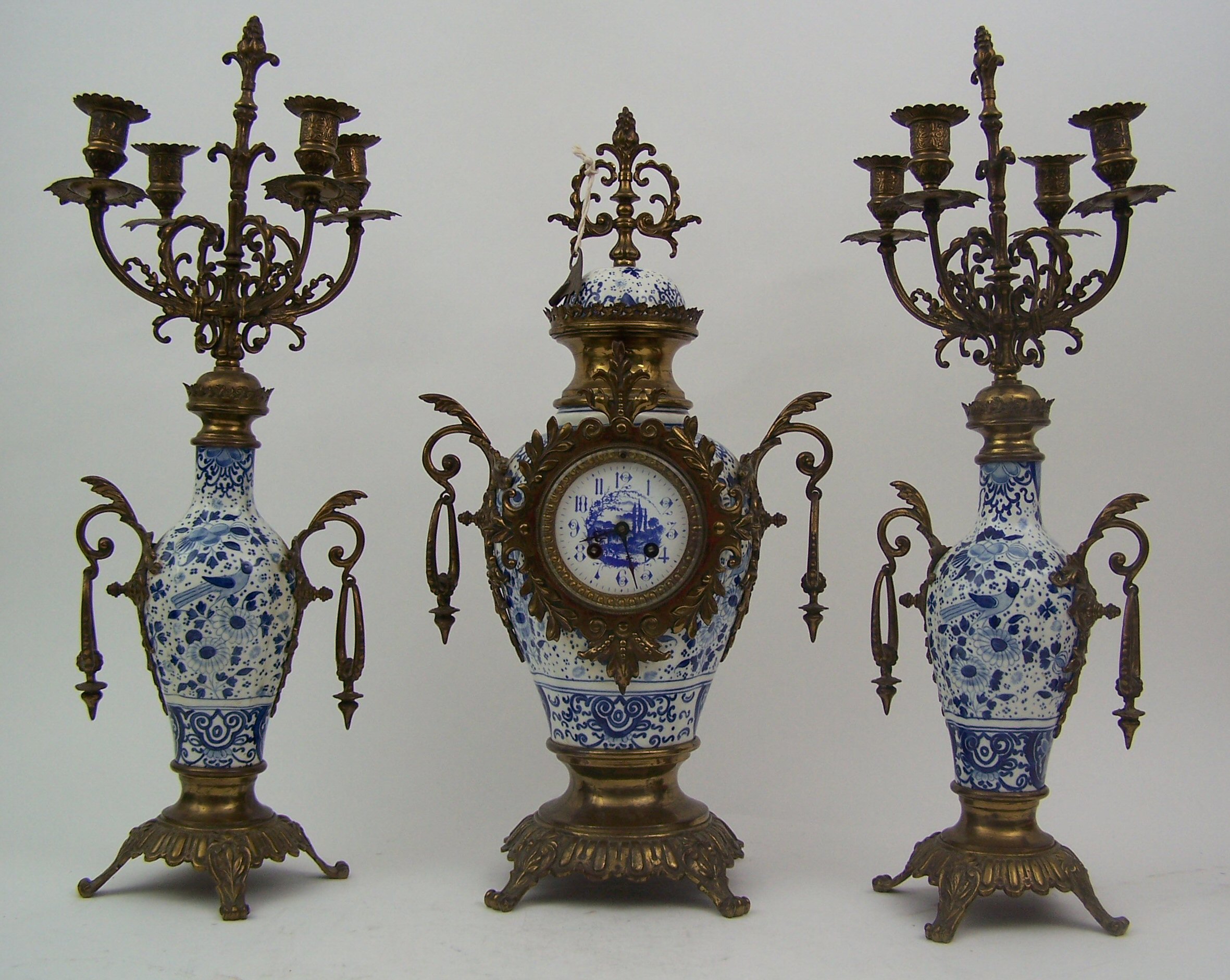 A late 19th century gilt metal and ceramic clock garniture,