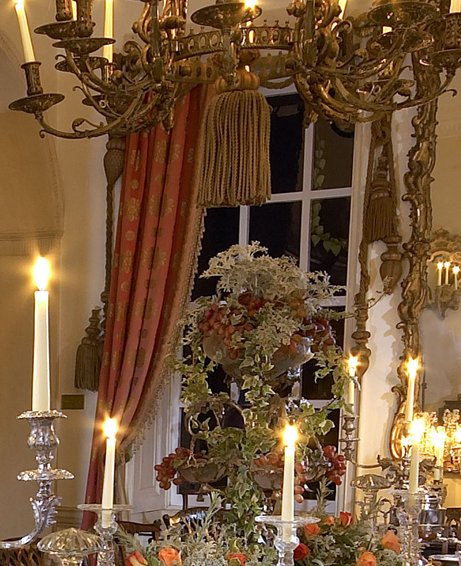 A pair of lined curtains, with brass rails and tie backs