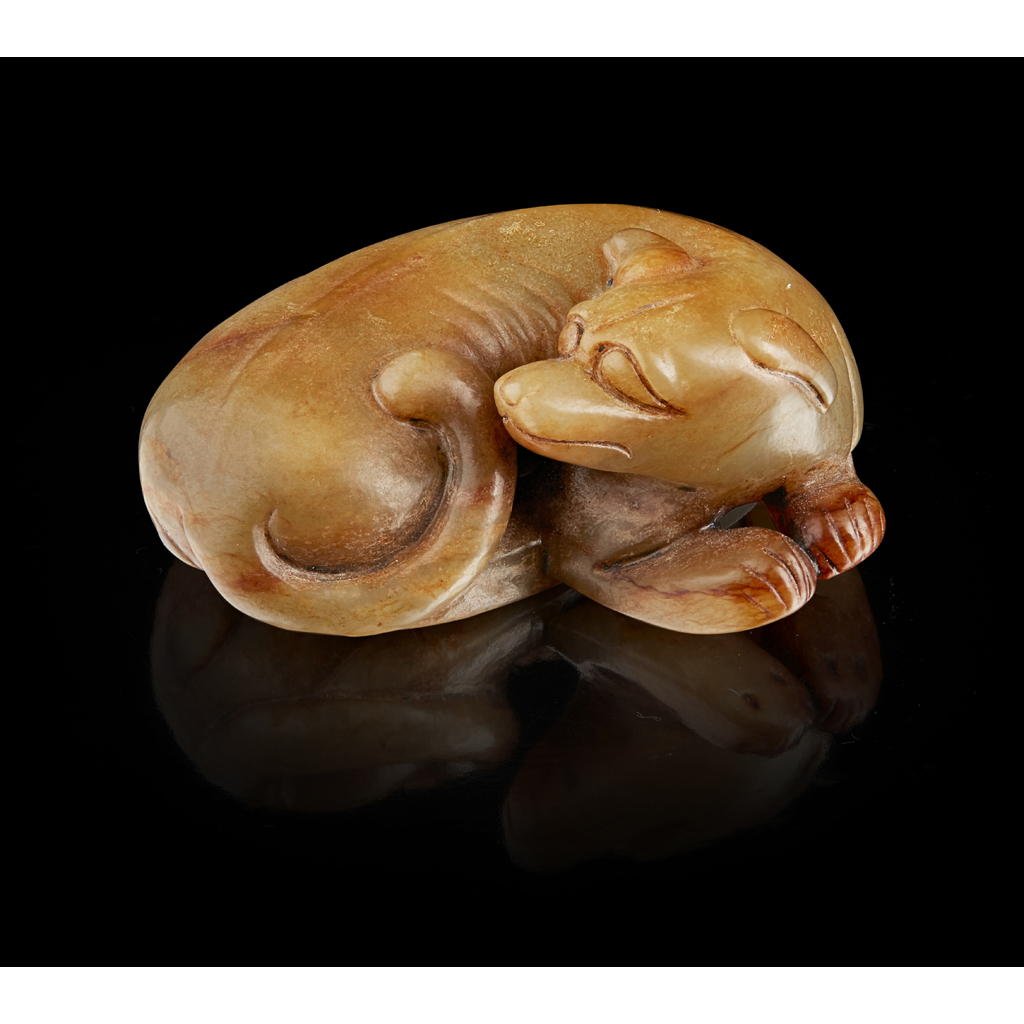 GREEN AND RUSSET JADE CARVING OF A DOG