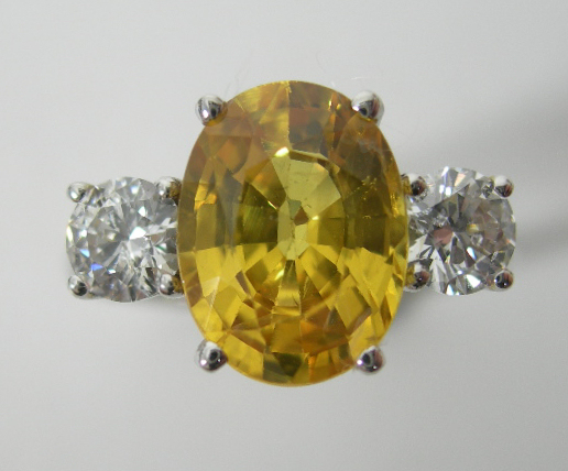 A yellow sapphire and diamond three-stone ring,