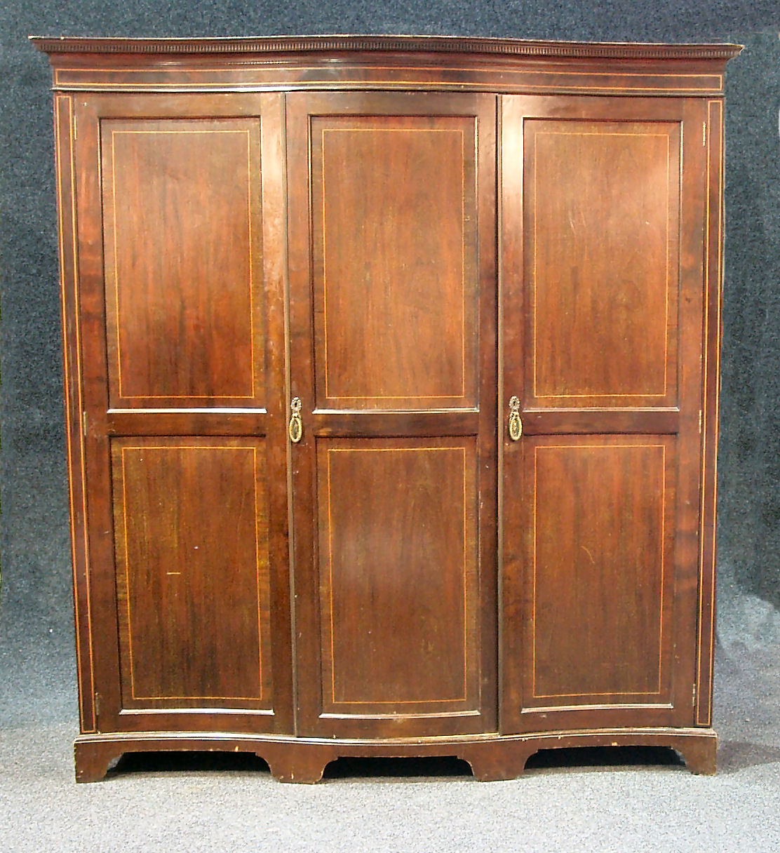 A mahogany serpentine wardrobe,
