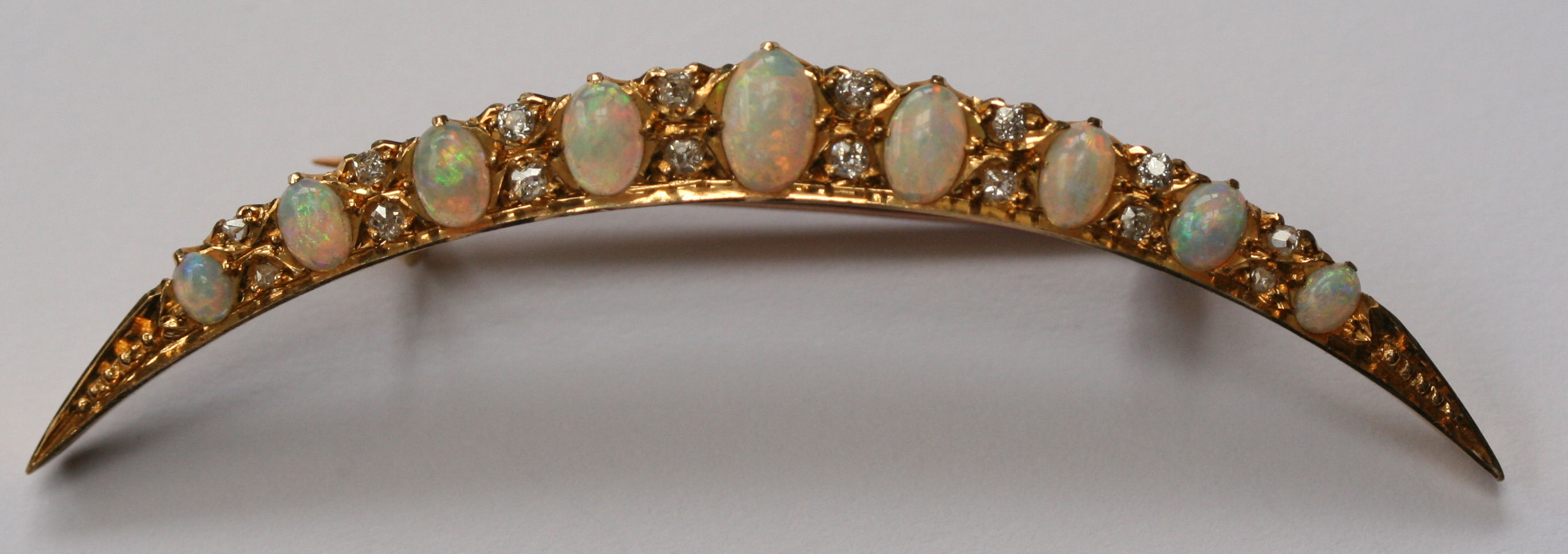 An Edwardian opal and diamond set crescent brooch