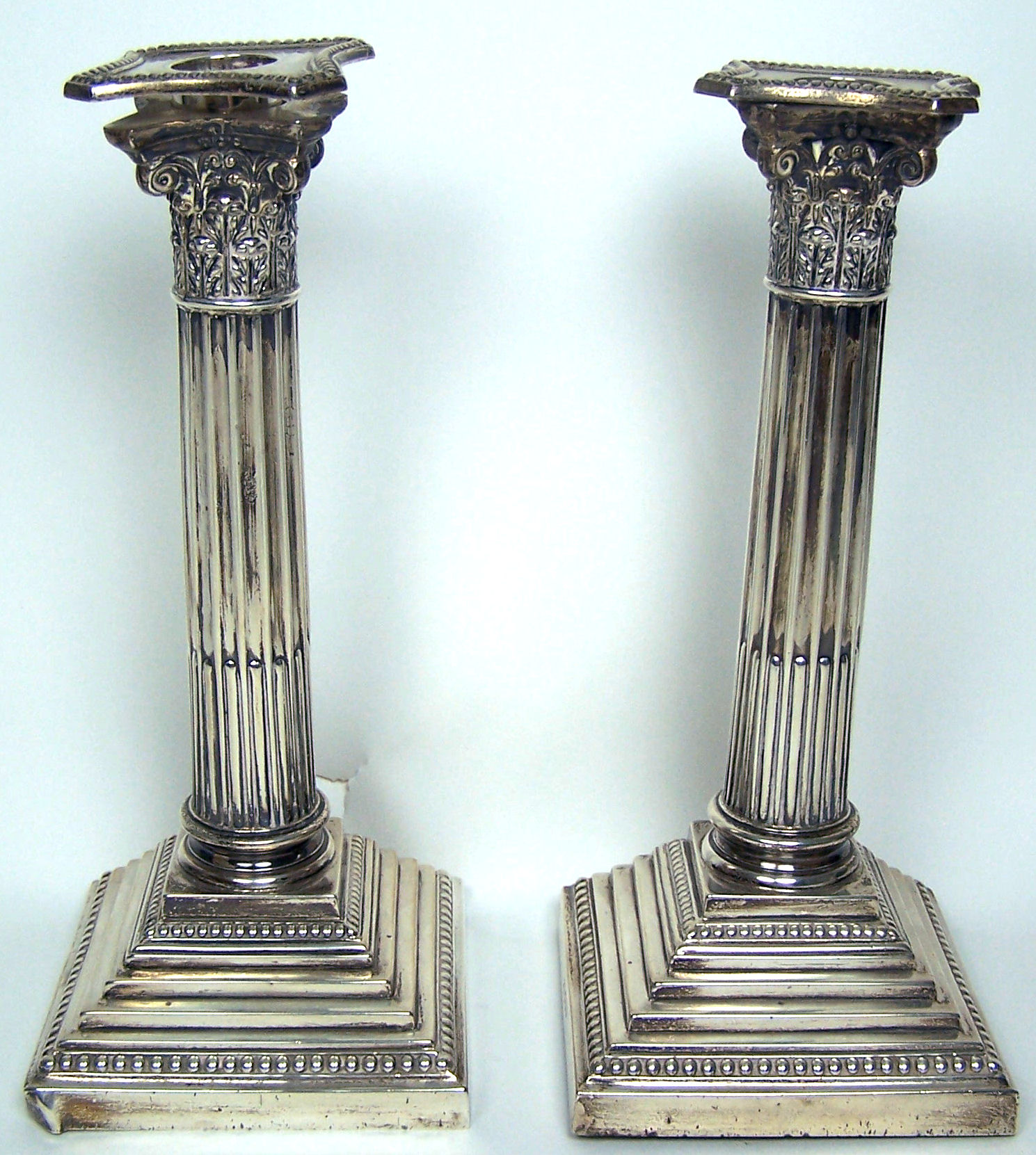 A pair of corinthian column candlesticks