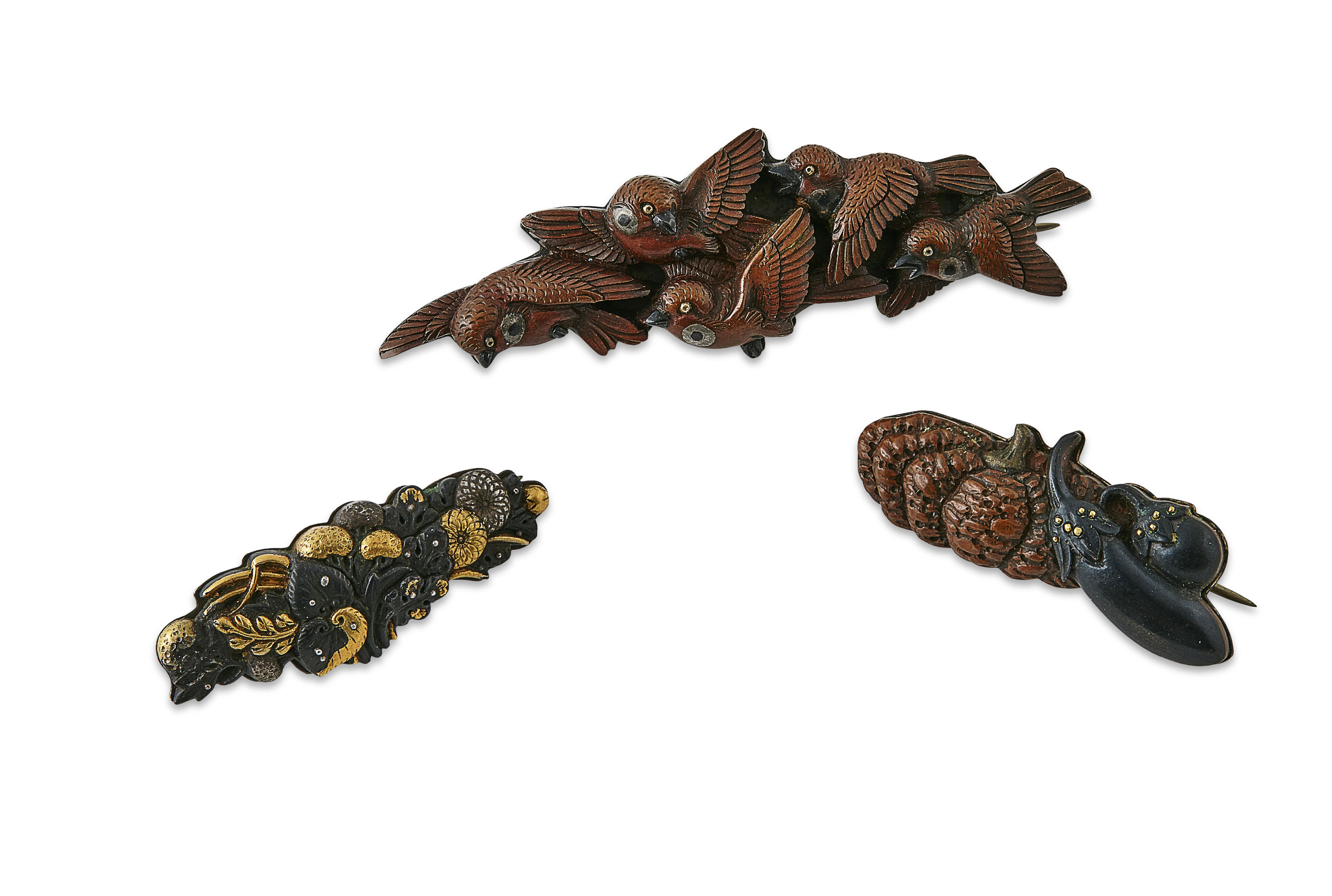 A group of three Japanese bronze and gilt menuki as brooches