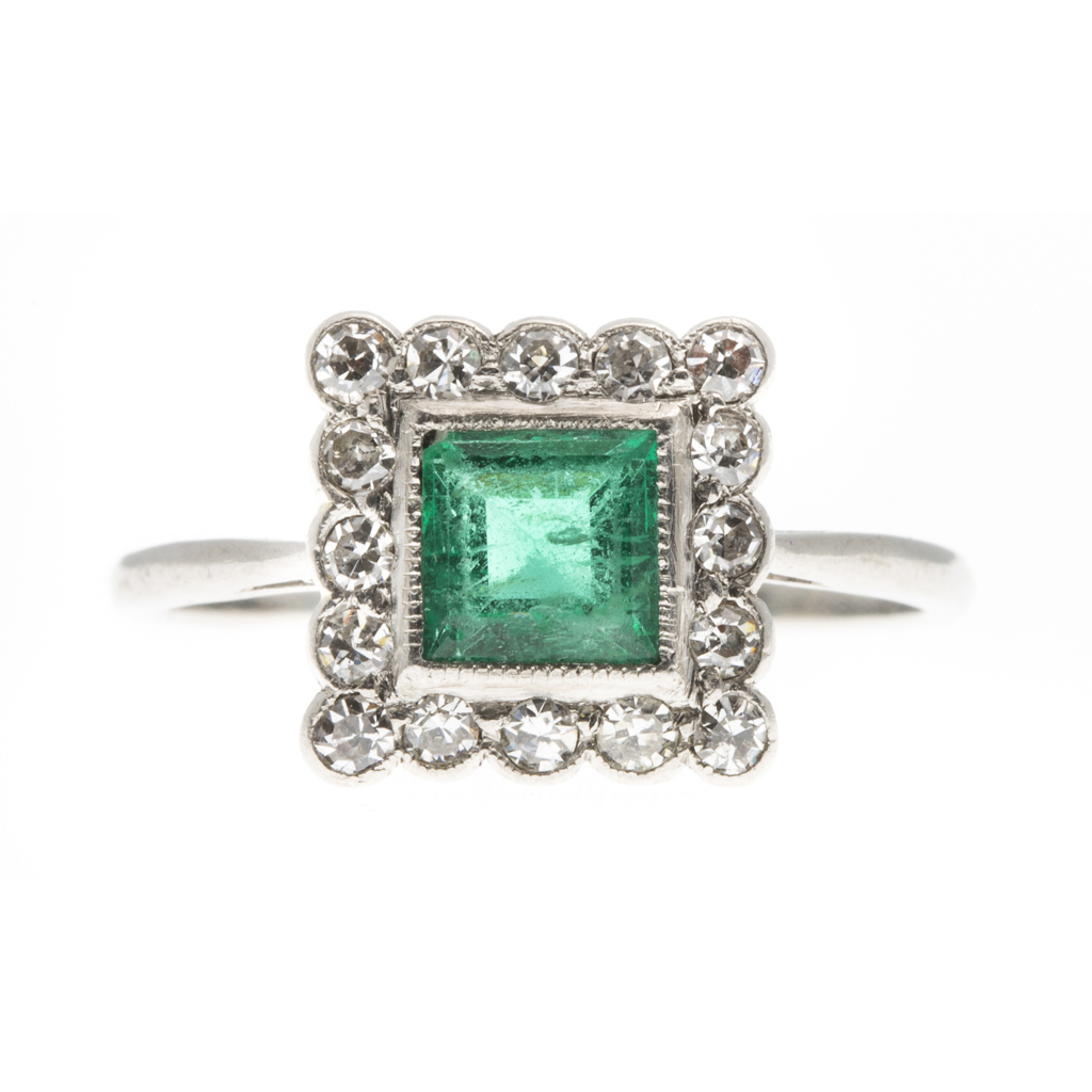 An emerald and diamond set cluster ring
