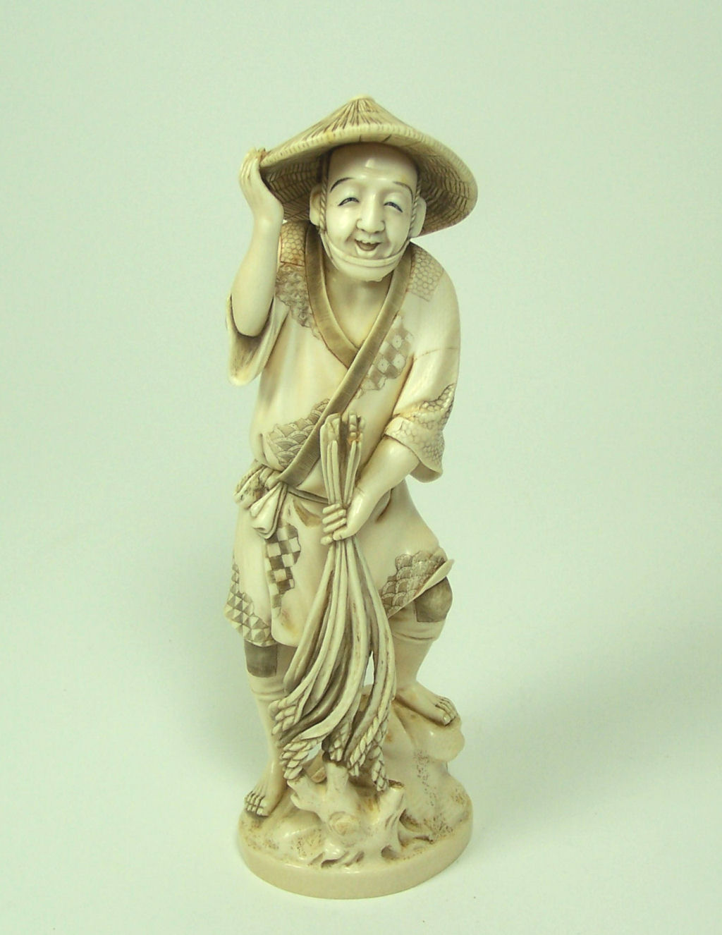 A Japanese ivory figure of a peasant, Meiji or Taisho period
