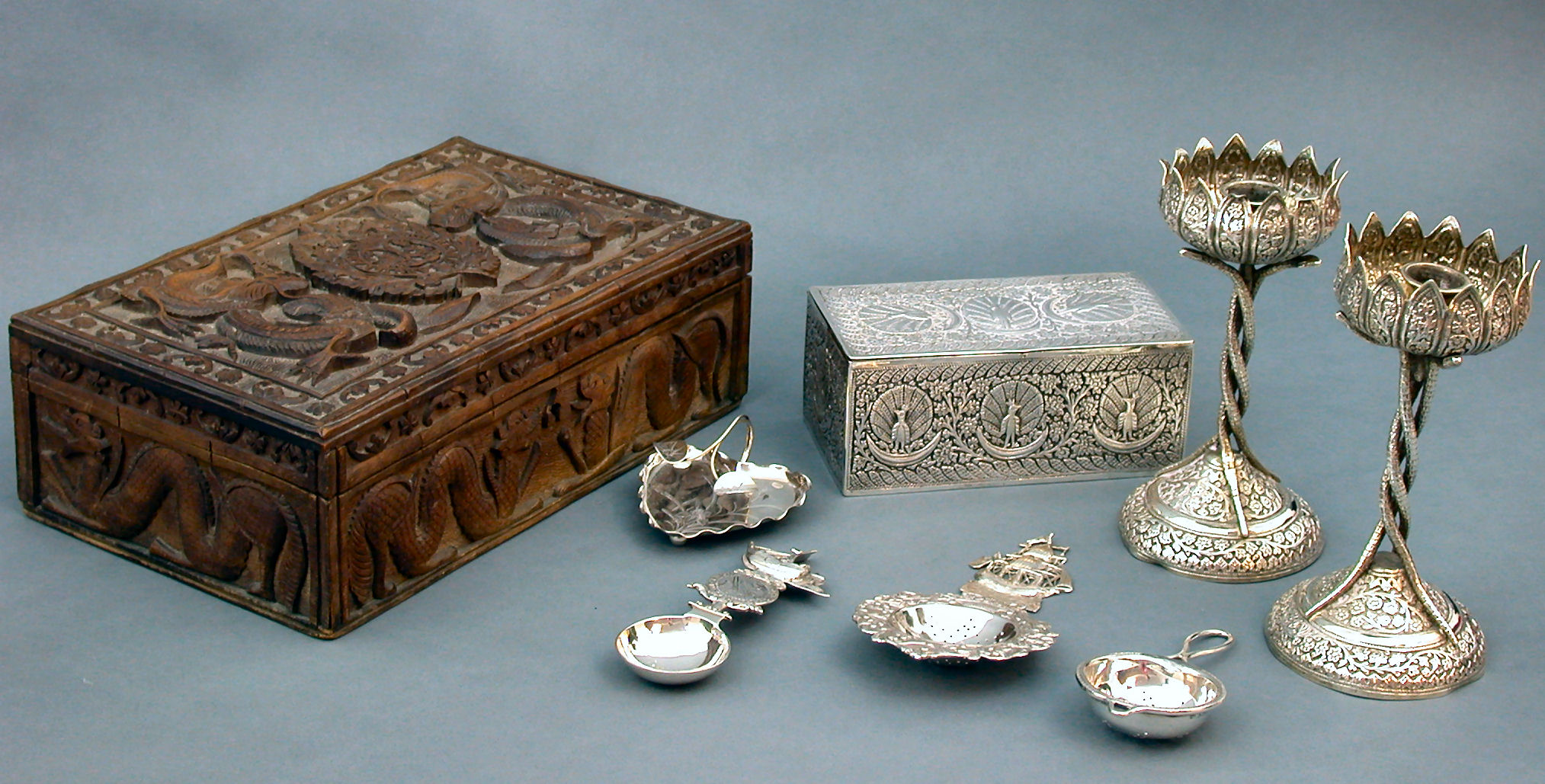 A pair of eastern white metal candlesticks,