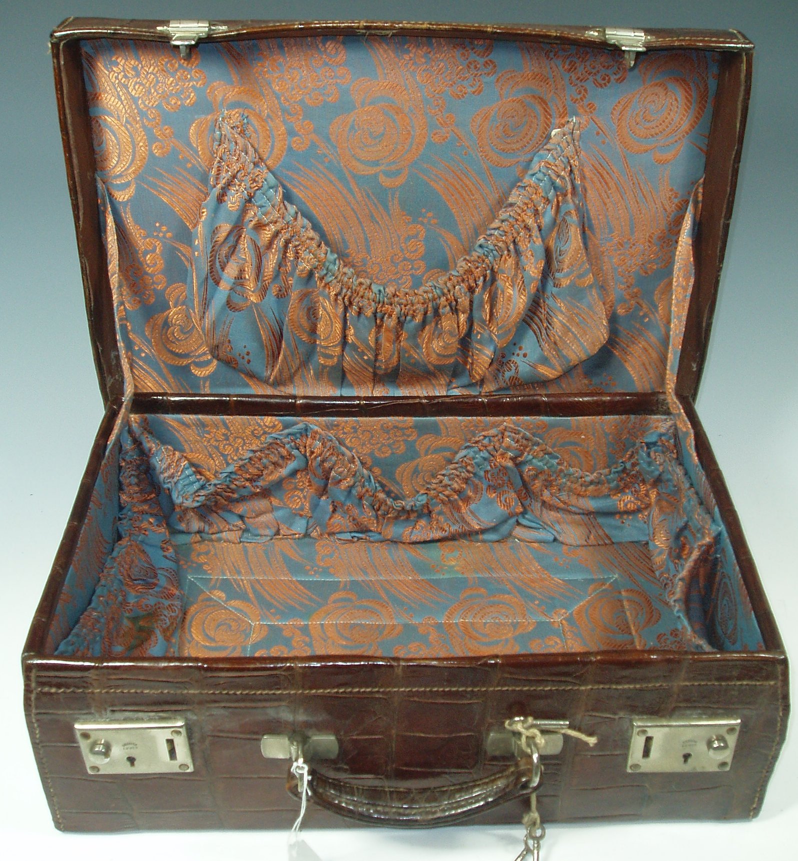 An early 20th century crocodile skin travelling case