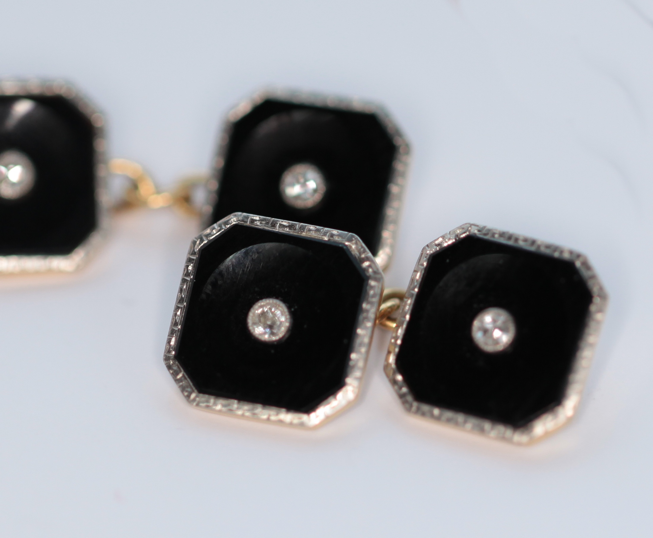 An early 20th century pair of 18ct gold and platinum mounted onyx and diamond set cufflinks
