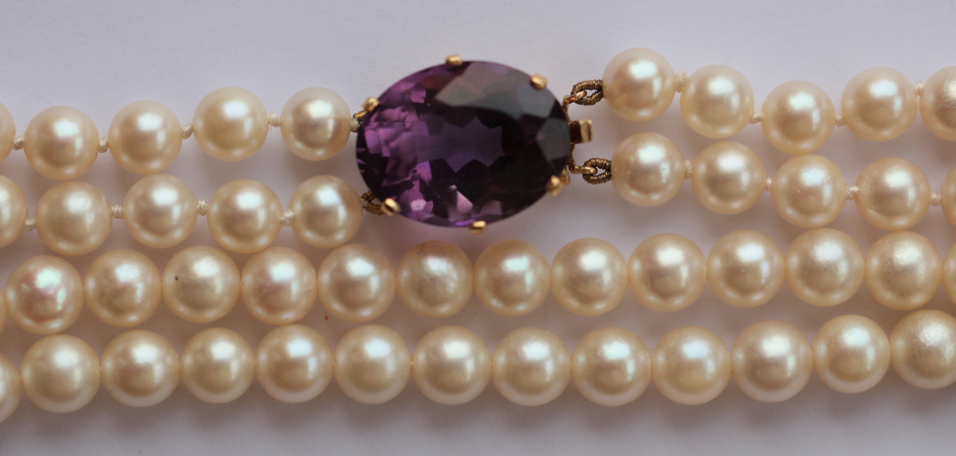 A two-row cultured pearl necklace with amethyst set clasp