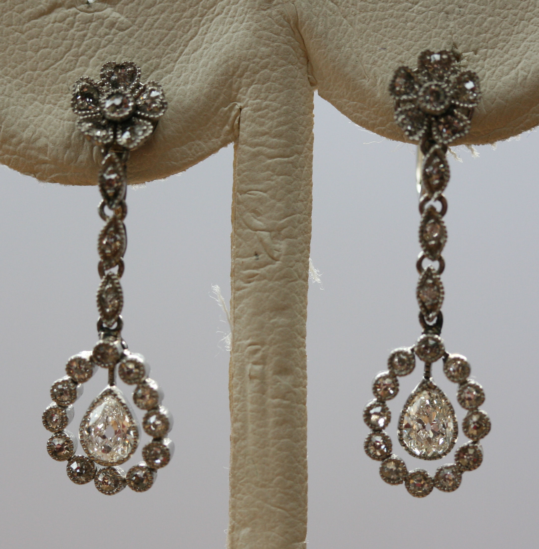 An early 20th century pair of 9ct white gold mounted diamond set pendant earrings