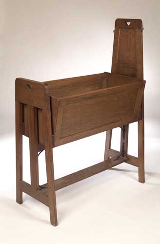 An Arts and Crafts Liberty style oak cradle,
