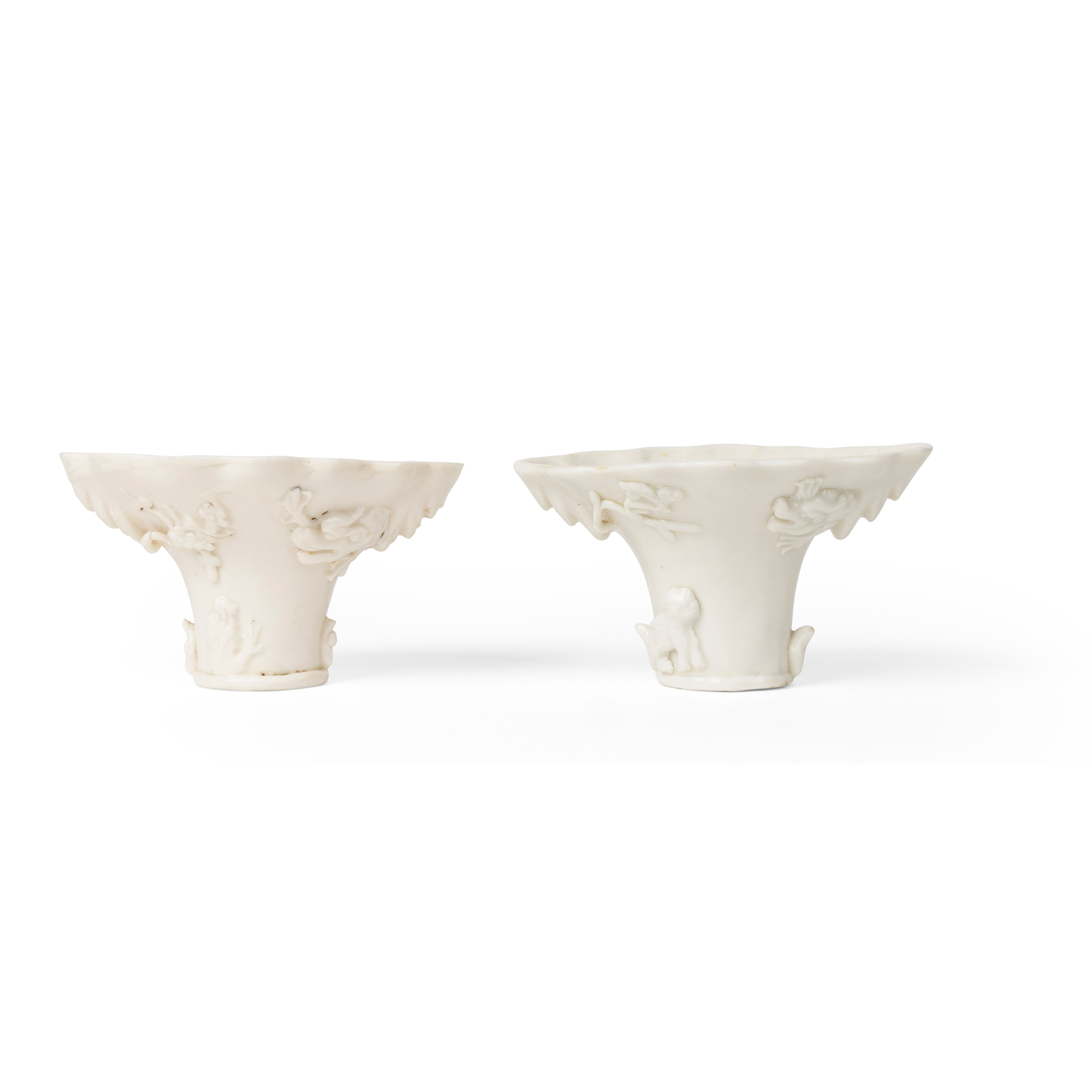 TWO DEHUA RHINOCEROS HORN-FORM LIBATION CUPS