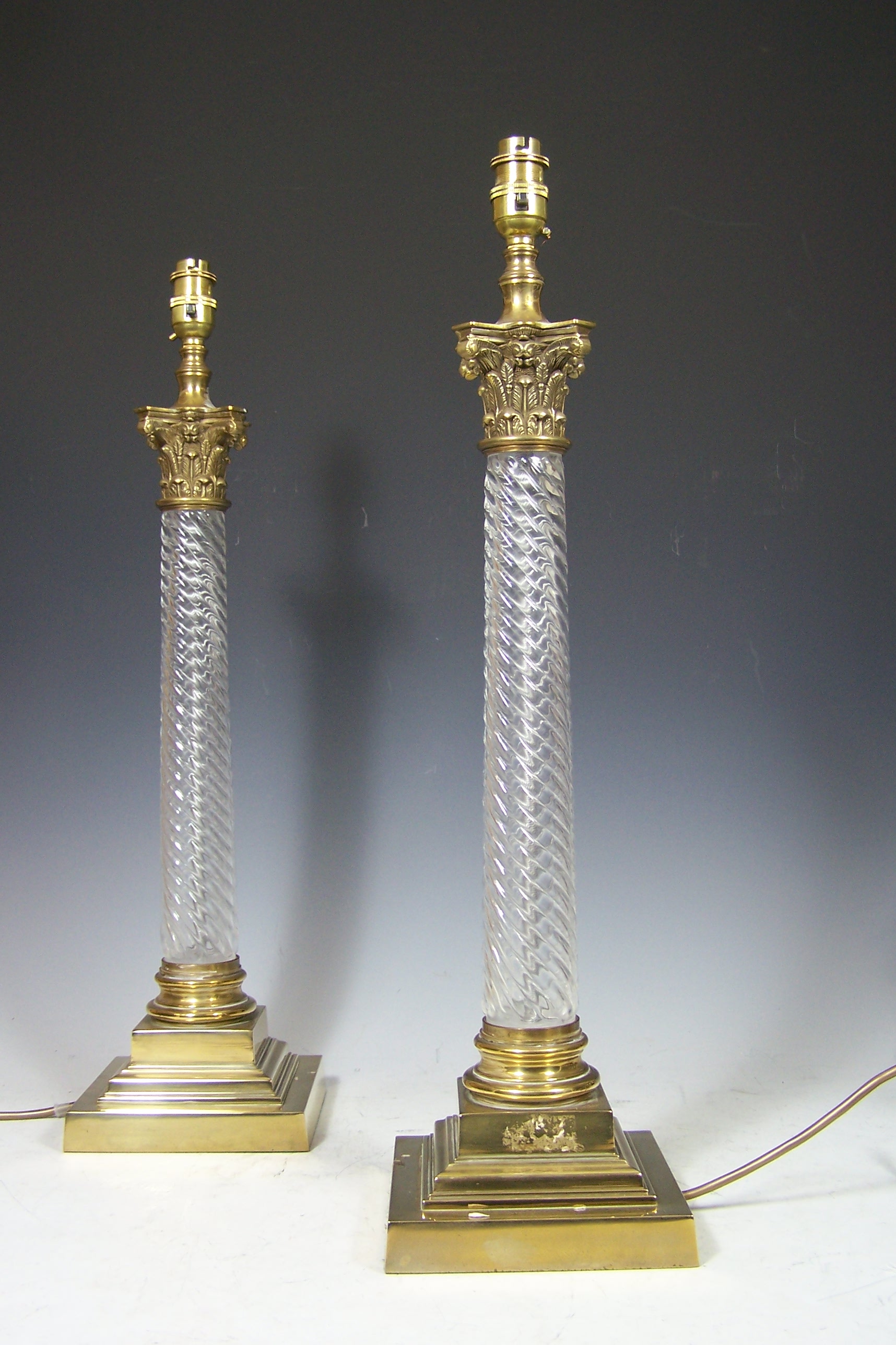 A pair of brass and glass lamp bases