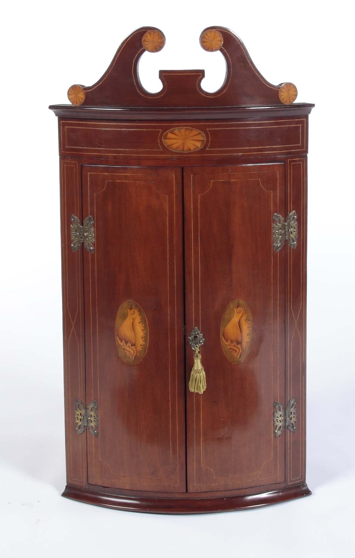 A small George III style mahogany and inlaid corner cupboard
