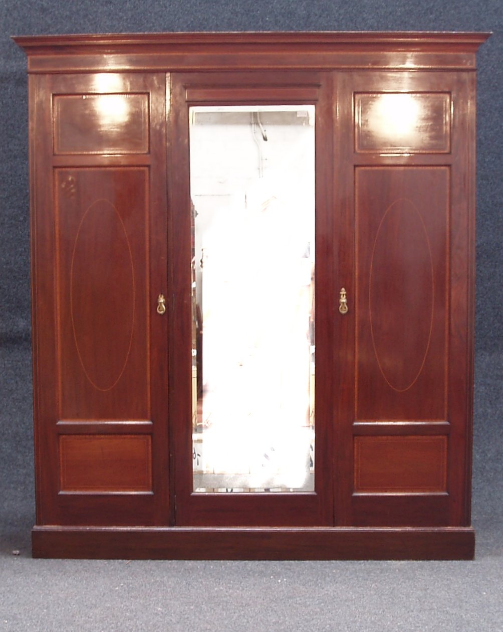 An Edwardian mahogany three door wardrobe,