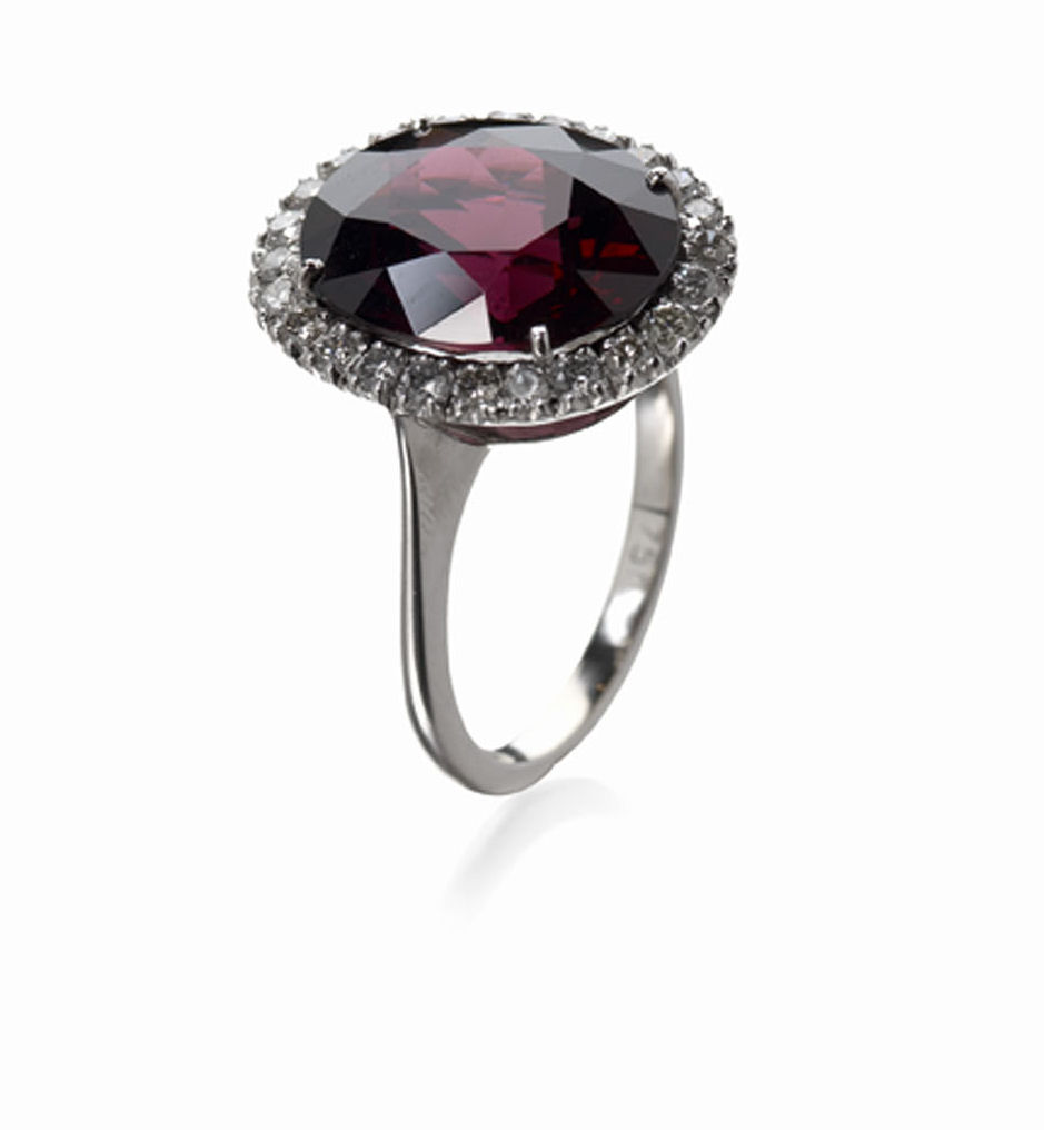 A garnet and diamond set oval cluster ring,