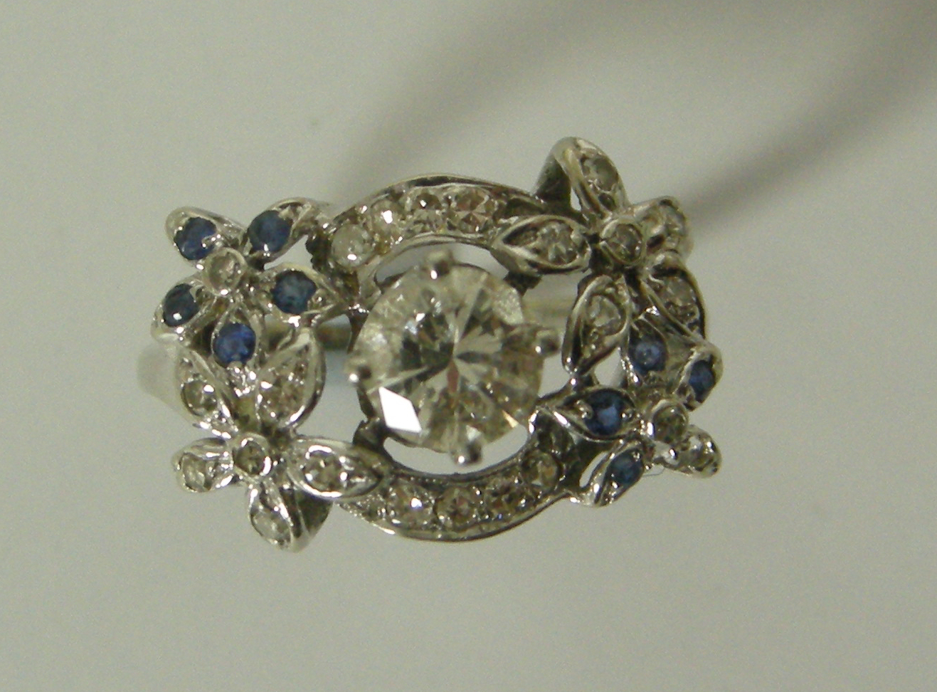 A diamond and sapphire floral ring