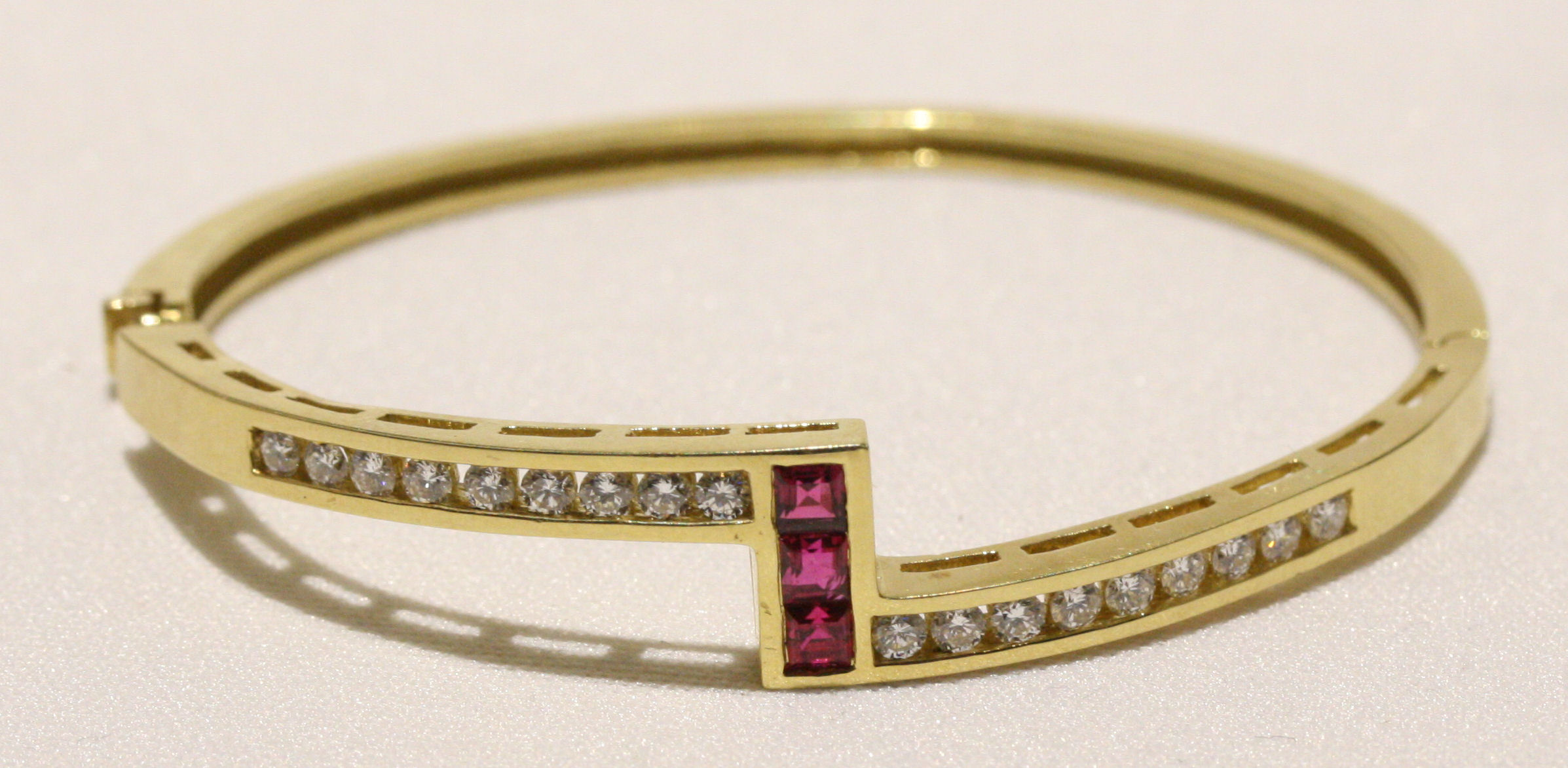 HAMMERMAN - an 18k gold ruby and diamond set bangle