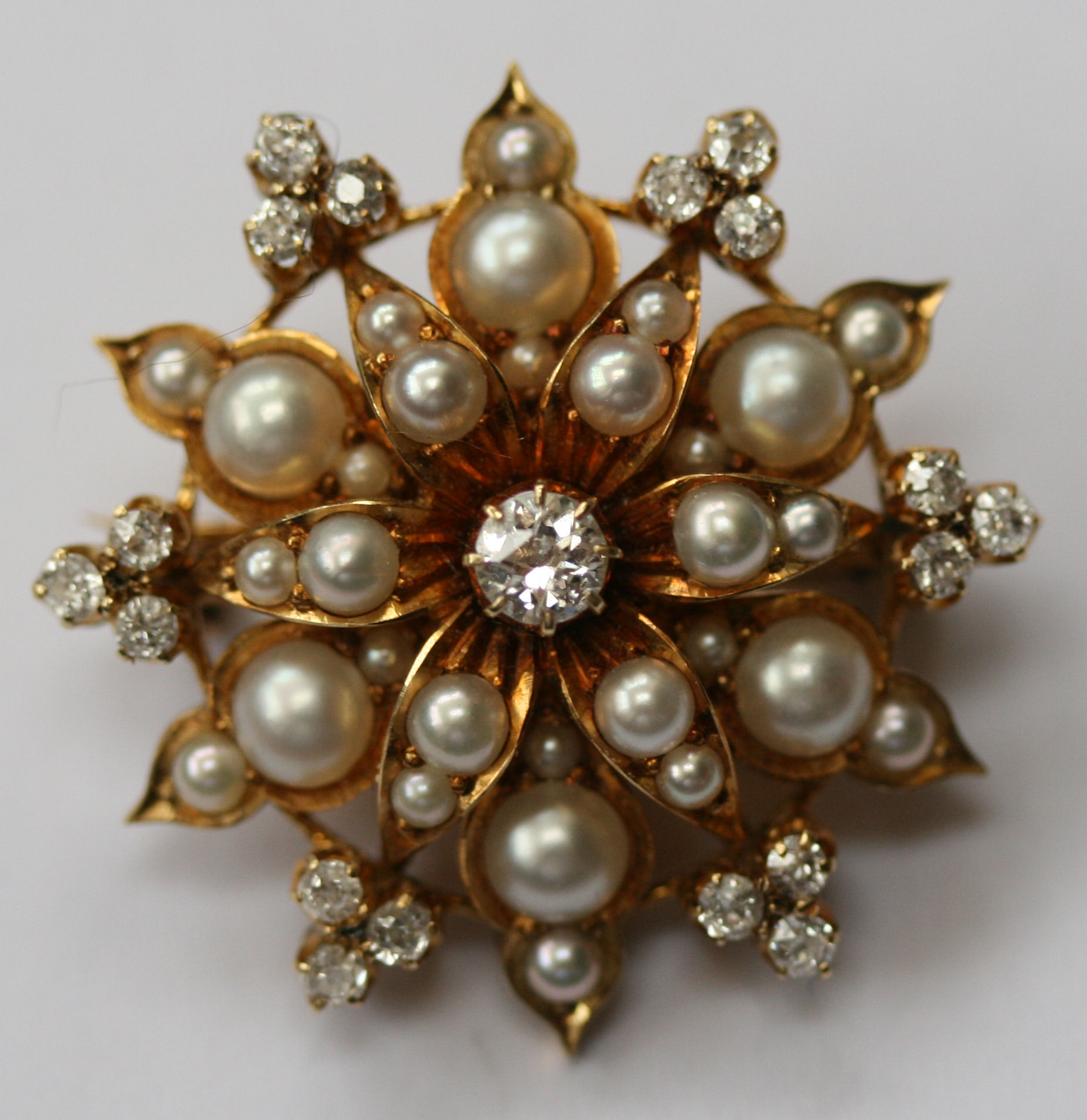 A late Victorian half-pearl and diamond set brooch/pendant