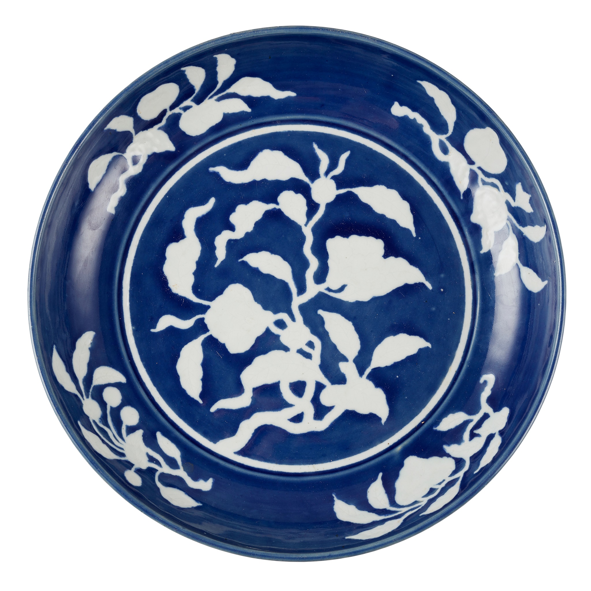 LARGE BLUE AND WHITE REVERSE-DECORATED 'FLOWER' PLATE