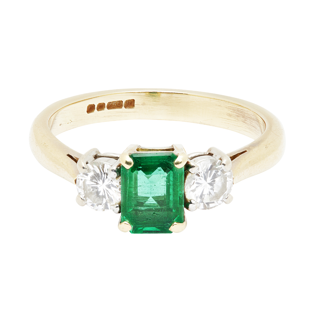 An emerald and diamond set three stone ring