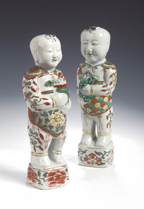 A matched pair of Chinese famille verte figures of standing boys, Kangxi,