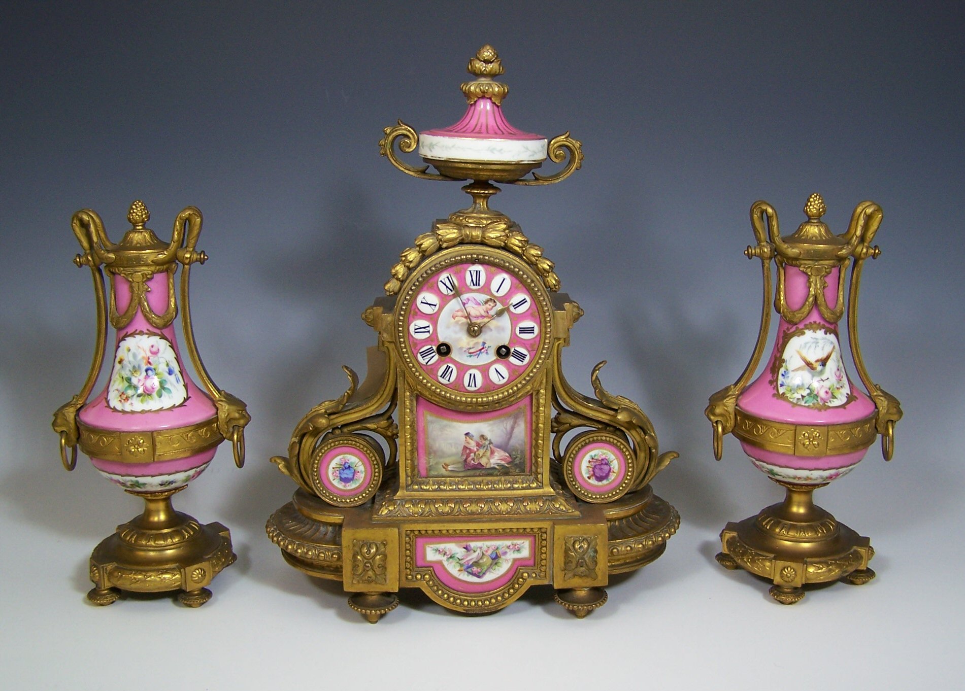 A 19th century French gilt and enamel clock garniture