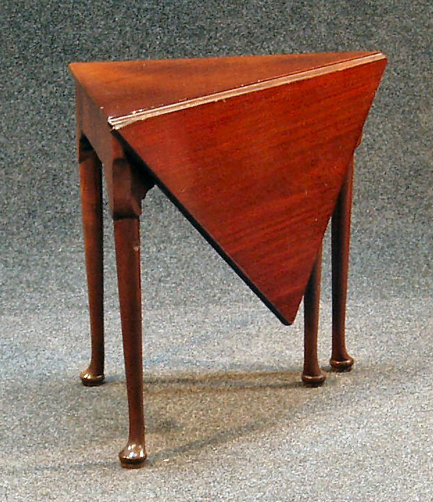 A George III mahogany triangular drop leaf table,