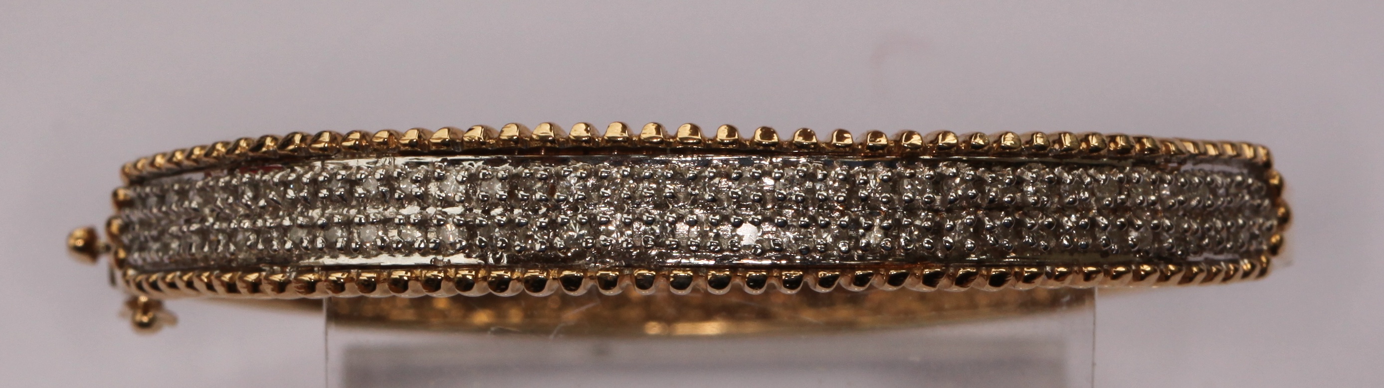 A diamond set two-coloured gold bangle